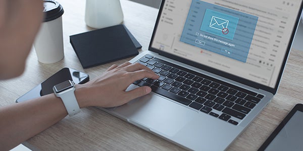 Person reviewing emails on laptop with pop up on screen saying do not show this message again